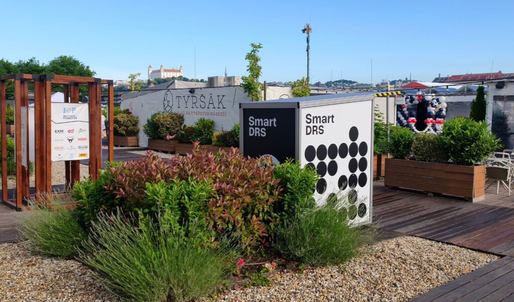 Smart DRS reusable cup return station at Tyršák in Bratislava, with Bratislava Castle visible behind it