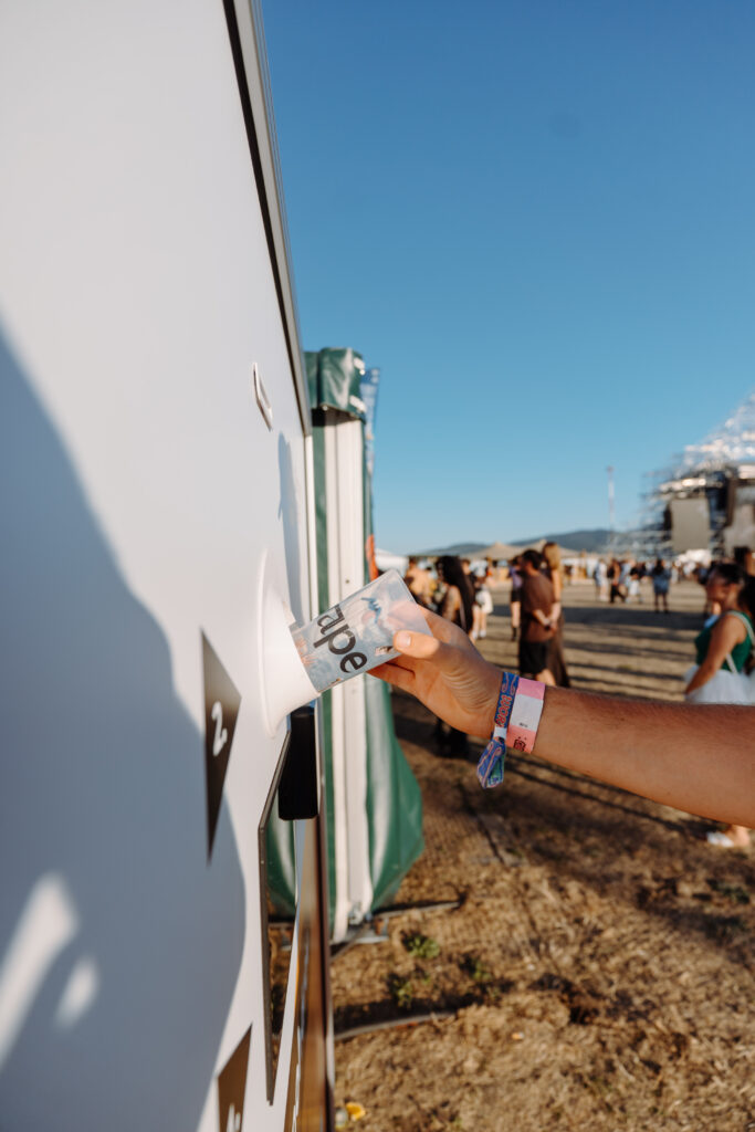 Close-up of a visitor inserting a reusable cup into a Smart DRS station at Grape Festival 2026