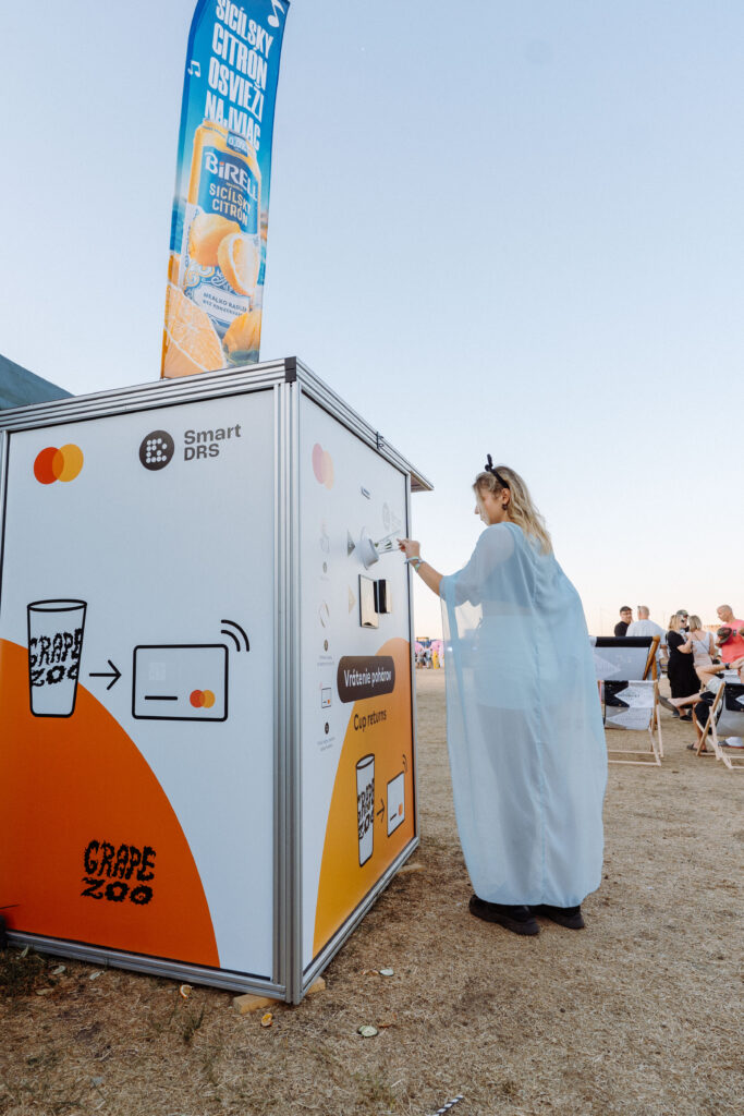 Festival visitor returning a reusable cup at a Smart DRS station during Grape Festival 2026