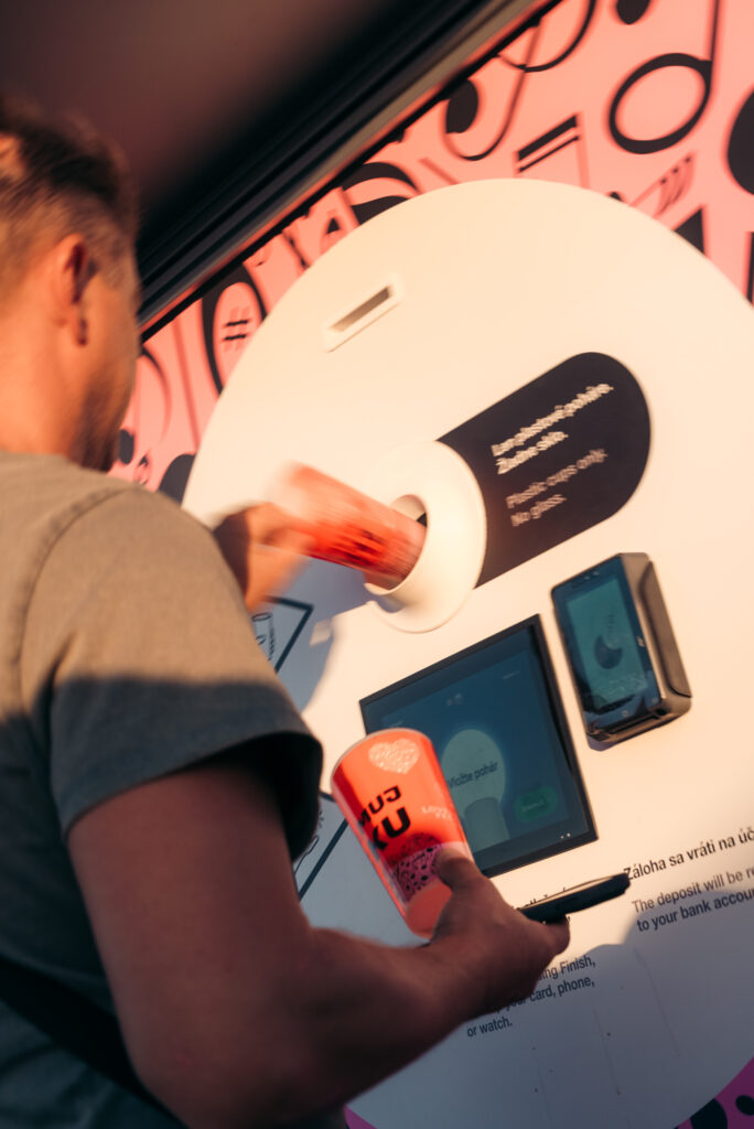 Festival visitor inserting a reusable cup into a Smart DRS return station at LOVESTREAM Festival 2026.