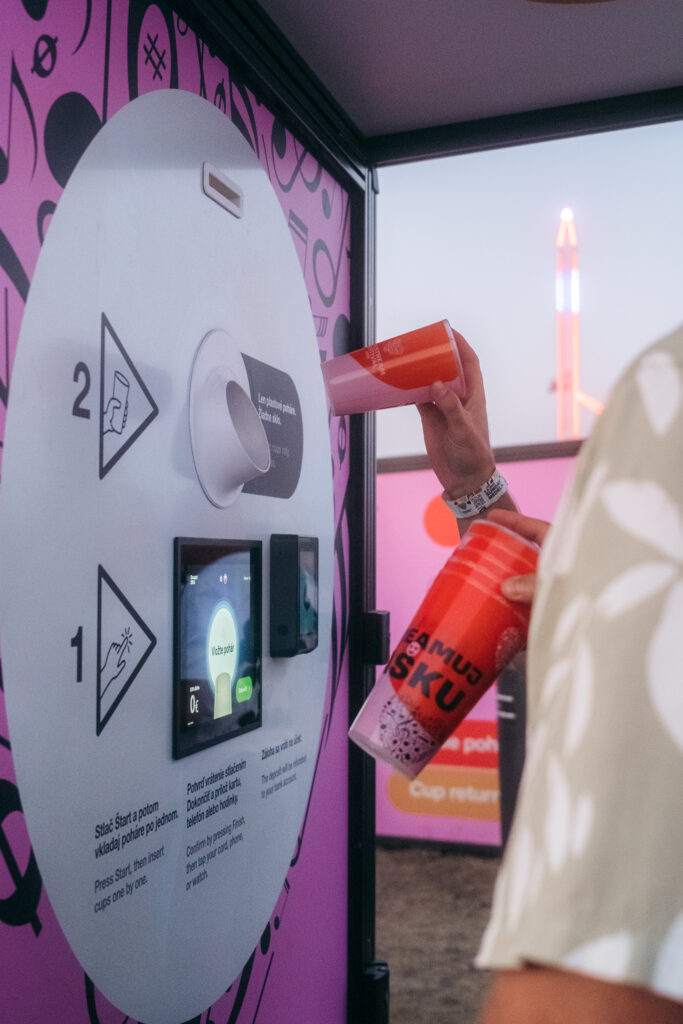 Festival visitor inserting a reusable cup into a Smart DRS return station at LOVESTREAM Festival 2026.