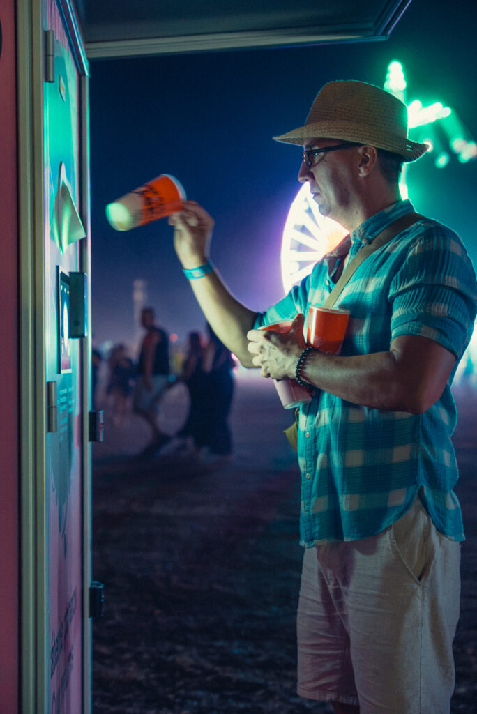 Návštevník festivalu v klobúku vracia vratný pohár do poháromatu Smart DRS počas festivalu LOVESTREAM 2026.